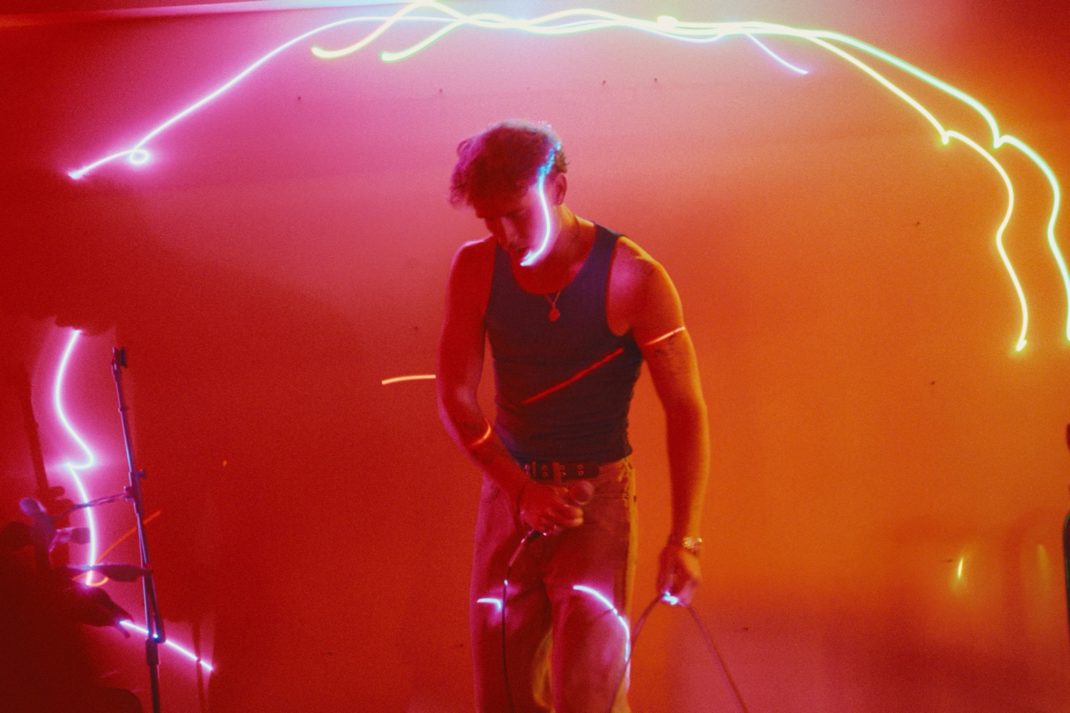 ProllyRed performing live under red, amber, and blue stage light on September 26, 2026